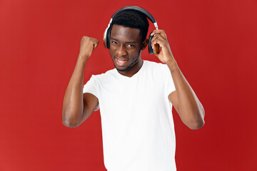 smiling man in headphones listening to music in white t-shirt isolated background