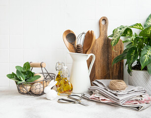 Kitchen utensils, tools and dishware on on the background white tile wall.