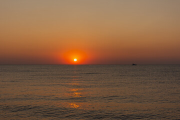 Sunset sea boat. Romantic summer landscape with a round orange sun. Minimalism in nature. The concept of summer, recreation, tourism, travel on a sea ship. tropical sunset or sunrise over the ocean