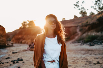 portrait of a beautiful girl at sunset. the wind develops hair harmony with nature on isolation, walks near the sea