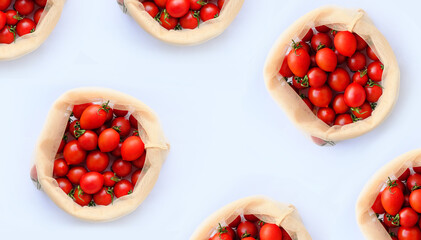 Isolated eco bag with red fresh bright organic tomatoes on a light natural background. Tomato template for your business. Empty space for your text or design.