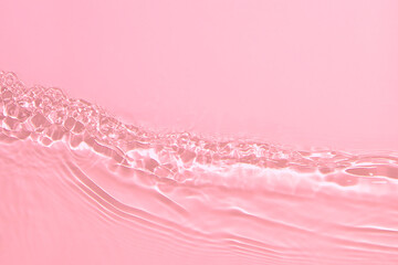 de-focused. Closeup of pink transparent clear calm water surface texture with splashes and bubbles. Trendy abstract summer nature background. Coral colored waves in sunlight. Copy space