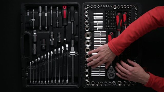 man using chrome tools and put them back in tool box from top view point