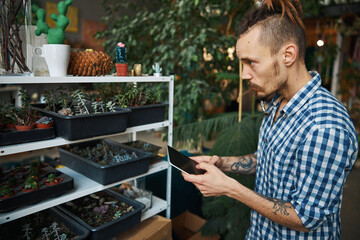 Handsome young man using digital tablet computer at home