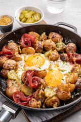 Potato hash with fried eggs and meat pastrami for breakfast branch