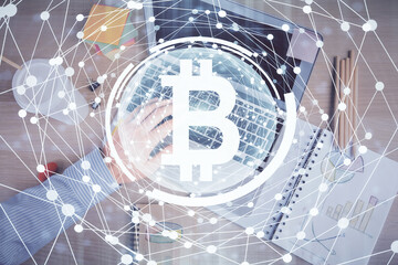 Double exposure of man's hands typing over computer keyboard and crypto currency theme hologram drawing. Top view. Blockchain concept.