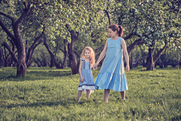 nature scene with family outdoor lifestyle. Mother and little daughter playing together in a park. Happy family concept. Happiness and harmony in family life.