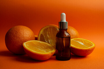 Cosmetic brown bottles on a orange background with oranges.
Cosmetic concept for branding and packaging.