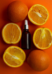 Cosmetic bottles on a orange background with citruses.
Cosmetic concept for branding and packaging.