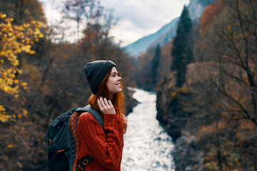 cheerful woman Tourist of all the law admires the nature of the mountain river