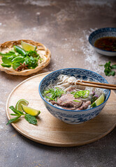 Chopsticks holding rice noodles with soup bowl - 438573764