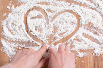 Heart of flour on wooden table