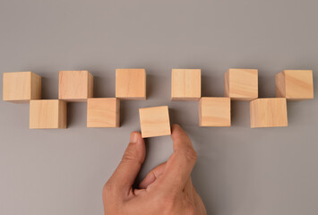 man hand choosing a wooden block from the group. Business choice, leadership and dissenting opinion...