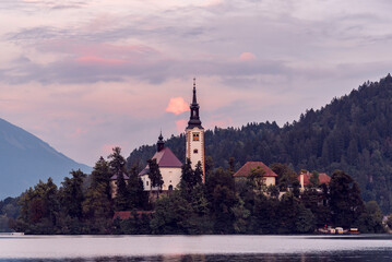 Fototapeta na wymiar Lake Bled in Slovenia viewed from the ground showing the pilgrimage church at sunset in beautiful orange colors