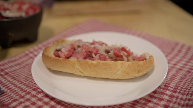 Traditional Mexican mollete on a plate above white and red checkered napkin