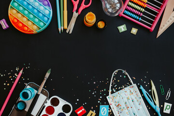 flatlay composition with a variety of stationery and pop i toy on blue background. copy space. back to school concept. new normal © ALL YOU NEED studio