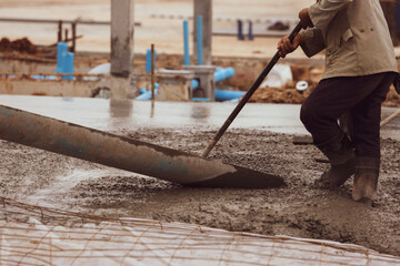 Workers are pouring cement on the construction site.