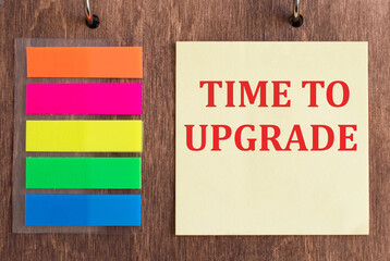 Text time to upgrade on yellow note paper on wooden background