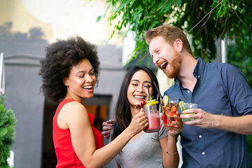 Multiracial group of friends having fun and talking in restaurant