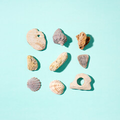 Summer concept with seashells and stones on blue background. Top view, flat lay.