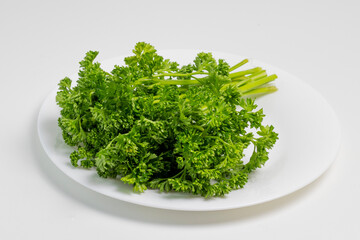 curly parsley on a plate on a white background