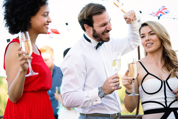 Group of friends drinking, chatting and having a fun at outdoor party