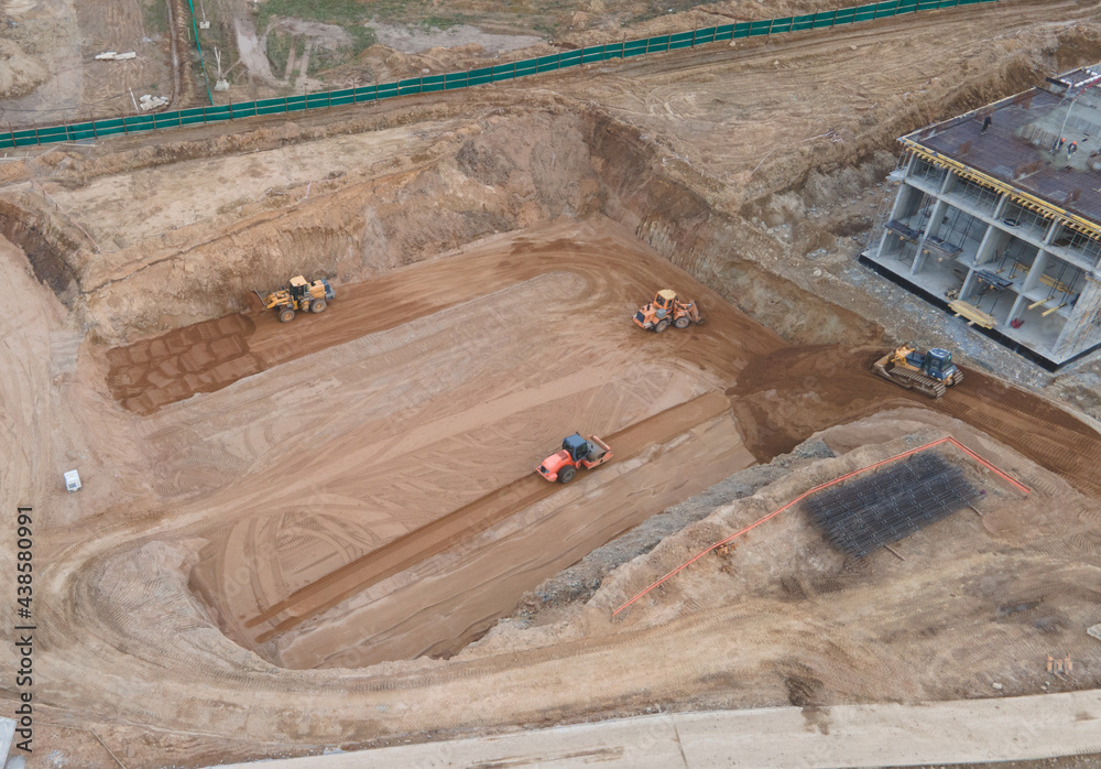 Poster Vibration road roller and wheel loader leveling ground for construct of foundation. Soil Compactor compresses soil under the formwork. Dozer at construction site.