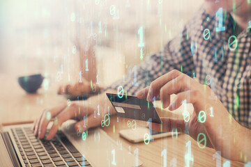 Double exposure of man hands holding a credit card and data theme drawing. E-commerce and...