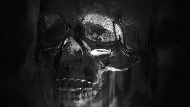 Skull Sparkles in Water Drops. Black and white skull in drops of water slowly turns against the background of slowly spreading steam