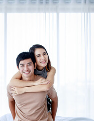 Cheerful Asian couple embracing at home