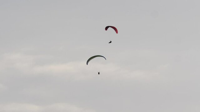 Paragliding. Extreme sport. Paragliders silhouette flying in blue sky. Spain Alicante Santa Pola region.