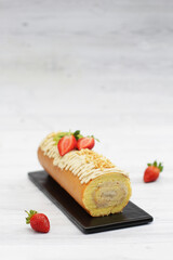 A sweet tiramisu roll cake with topping tiramisu cream, peanut crumble and slice strawberry