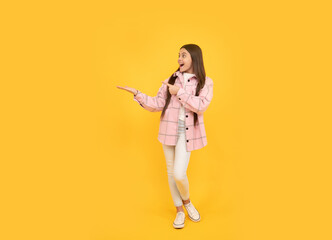 Fototapeta na wymiar happy child girl wear pink checkered shirt presenting product, copy space, advert