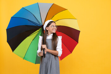 cheerful teen child under colorful parasol. kid in beret with rainbow umbrella.
