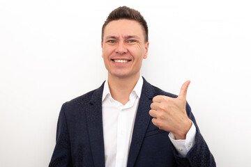 Business man in a jacket and white shirt smiles and shows a thumb up on a white background. Approval of choice