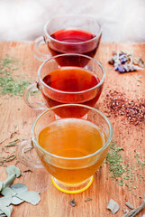 various herbal teas in glass cups on wooden surface
