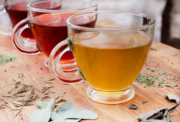 various herbal teas in glass cups on wooden surface