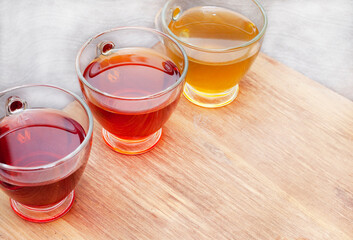 various herbal teas in glass cups on wooden surface