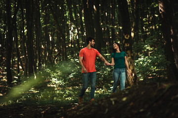 Naklejka na ściany i meble Young couple enjoys together walking through the forest.
