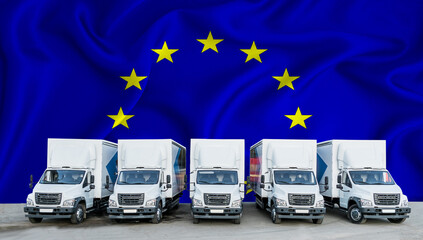 EU flag in the background. Five new white trucks are parked in the parking lot. Truck, transport, freight transport. Freight and logistics concept - obrazy, fototapety, plakaty
