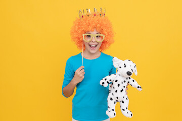 happy teen girl in fancy clown wig wear queen crown and funny party glasses hold toy, childhood