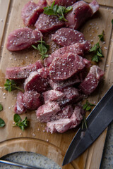 raw meat pieses on a wooden plate