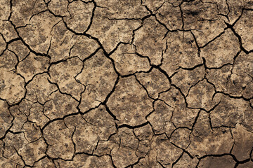 Texture of cracked dried soil. Dry ground with cracks. Brown rough surface of the soil during summer drought. Great for background and design. Ecology, climate change and global warming on Earth.