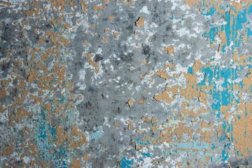 Peeling paint on the wall. Old concrete wall with cracked flaking paint. Weathered rough painted surface with patterns of cracks and peeling. Grunge texture for background and design. High resolution.