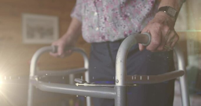 Animation of glowing light over senior man with walking frame