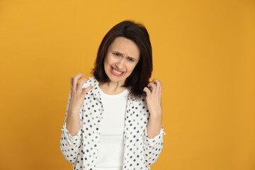 Portrait of angry woman on yellow background. Hate concept