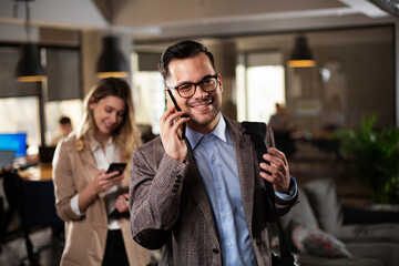 Portrait of handsome businessman. Young businessman using the phone in te office..