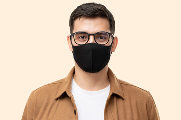 Portrait of young man wearing trendy brown cargo shirt, glasses and black face mask