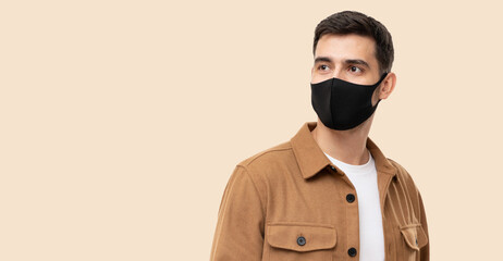 Banner of young man in brown cargo shirt and black face mask looking away