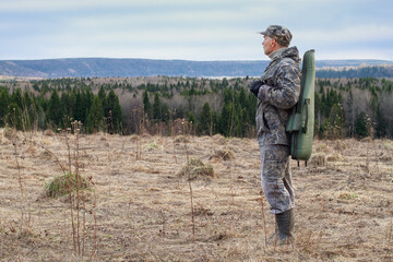 a shotgun case is slung over the shoulder of a hunter